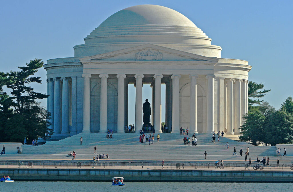 Jefferson Memorial with neoclassical dome pillars river paddle boats clear blue sky wallpaper