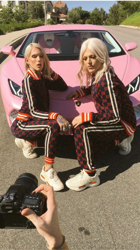Jeffree Star in matching designer tracksuit posing with pink Lamborghini for glam wallpaper background