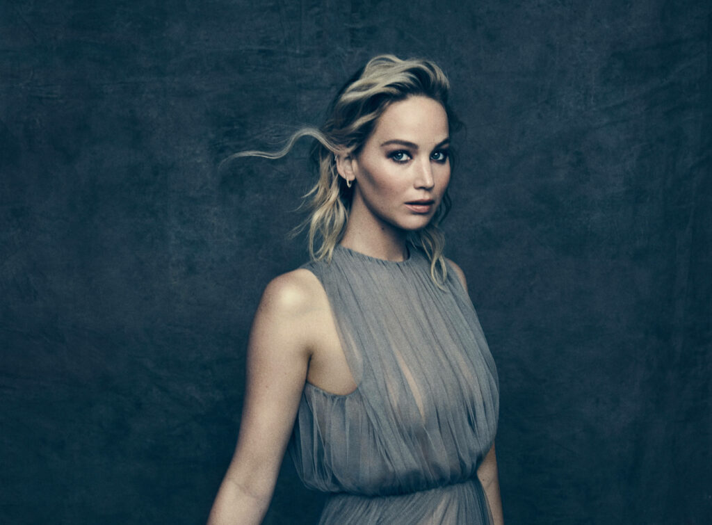 Jennifer Lawrence in sheer elegant dress dark textured backdrop confident graceful pose Wallpaper