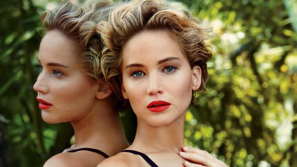 Jennifer Lawrence in red lipstick with elegant reflection against lush green wallpaper background