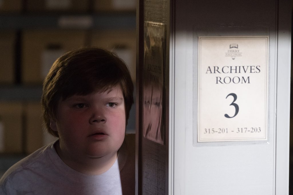 Jeremy Ray Taylor as Ben Hanscom peeks around Archives Room pillar Derry Library It 2017 horror film Wallpaper