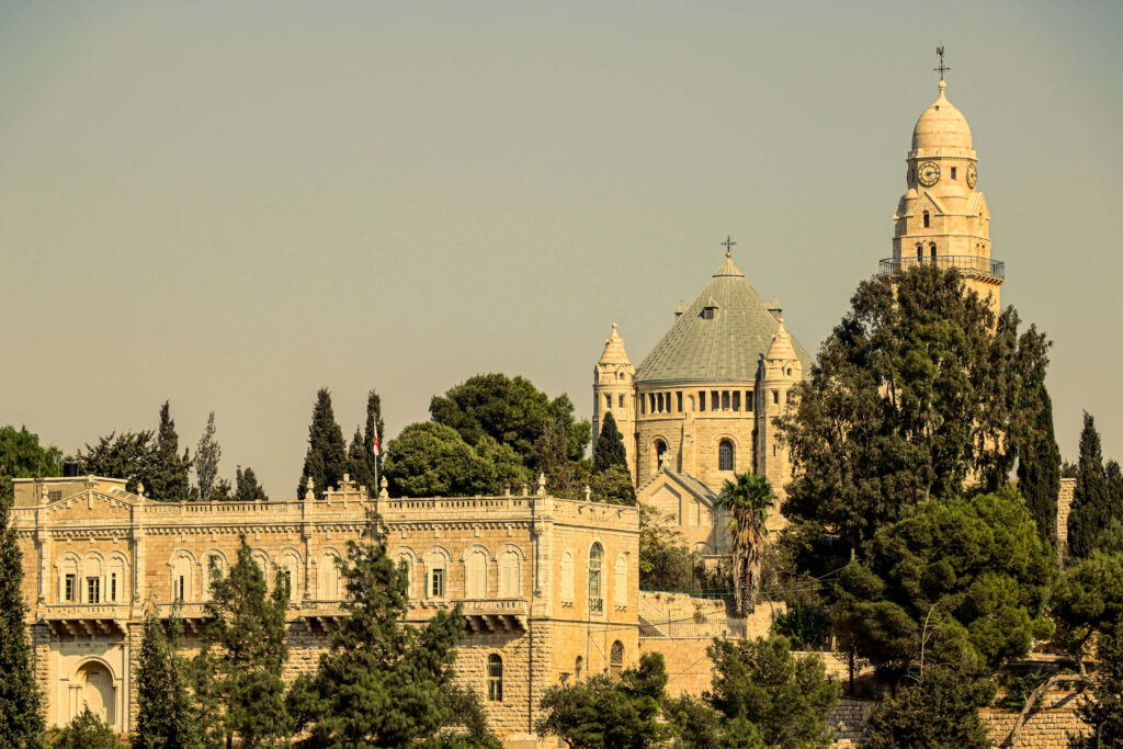 Jerusalem historic architecture at dusk with ancient stone buildings and lush greenery background Wallpaper