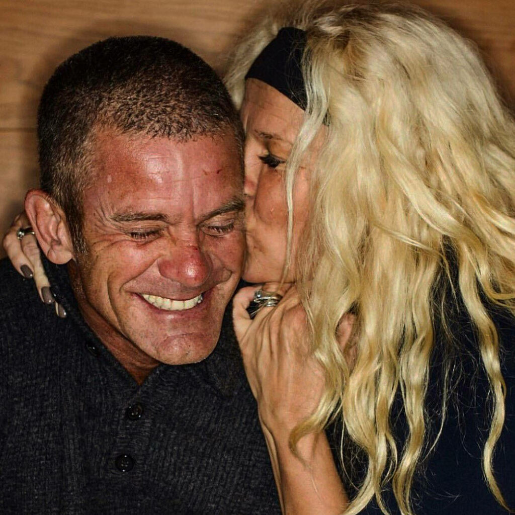 Jesper Parnevik and wife sharing a joyful affectionate moment kissing cheek loving wallpaper background