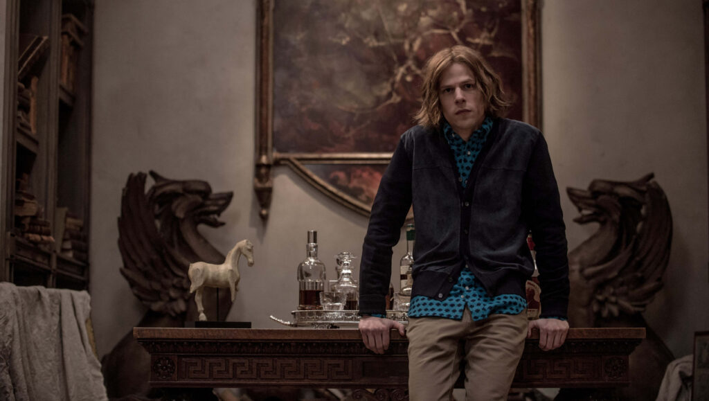 Jesse Eisenberg intense dramatic scene leaning on grand wooden table in ornately decorated room Wallpaper