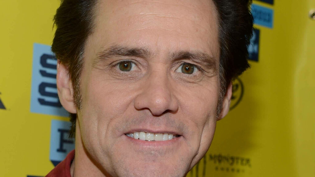 Jim Carrey close-up bright smile yellow background with logos vibrant wallpaper background