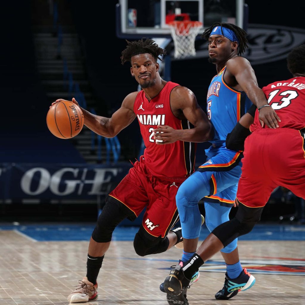 Jimmy Butler dribbles past Luguentz Dort with Bam Adebayo in Miami Heat NBA game action wallpaper