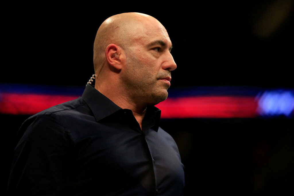 Joe Rogan focused in UFC octagon ready for live mixed martial arts commentary wallpaper background