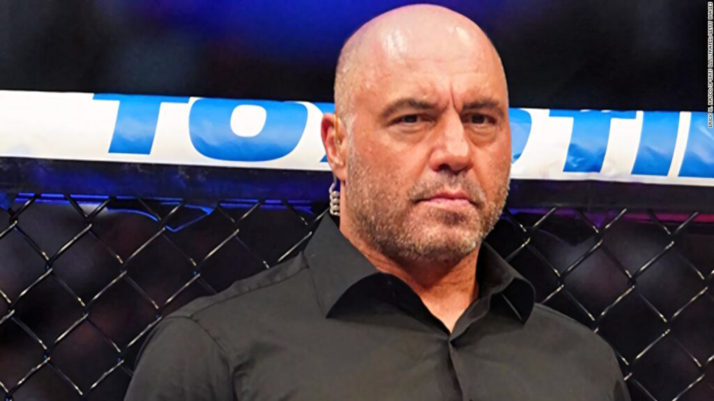 Joe Rogan inside UFC octagon serious expression ready for commentary fight arena background Wallpaper