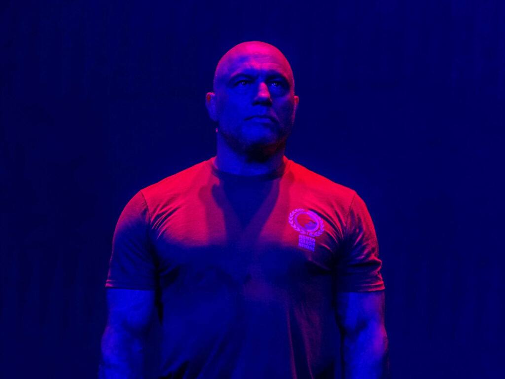 Joe Rogan under intense ultraviolet lighting dramatic bold visual effect unique wallpaper background