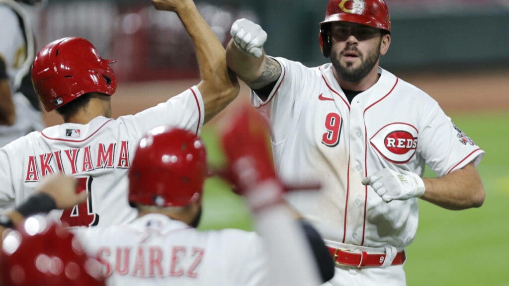 Joey Votto and Cincinnati Reds celebrating on field vibrant red white uniforms dynamic team spirit wallpaper
