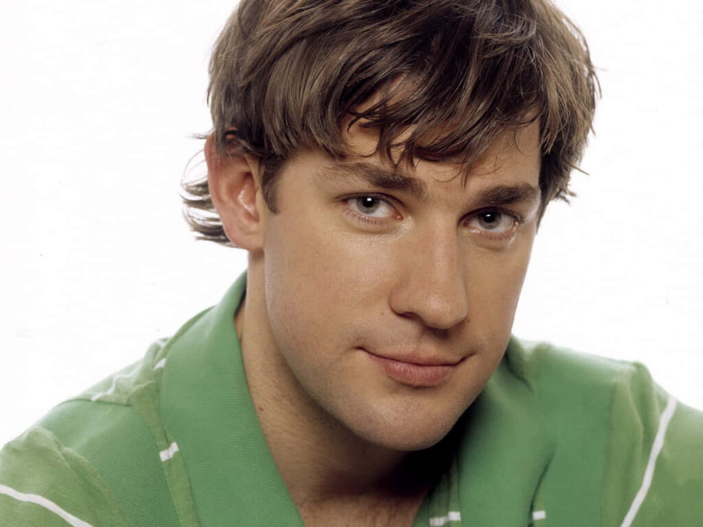 John Krasinski in light green shirt smiling warmly on simple clean background wallpaper