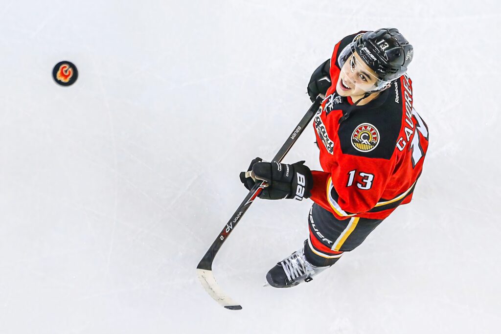 Johnny Gaudreau skating in red Calgary Flames jersey intense ice hockey action wallpaper