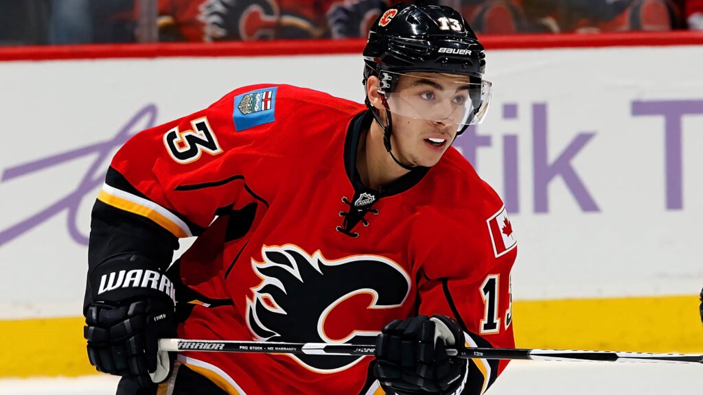 Johnny Gaudreau in red Calgary Flames jersey number 13 showcasing intense ice hockey action Wallpaper