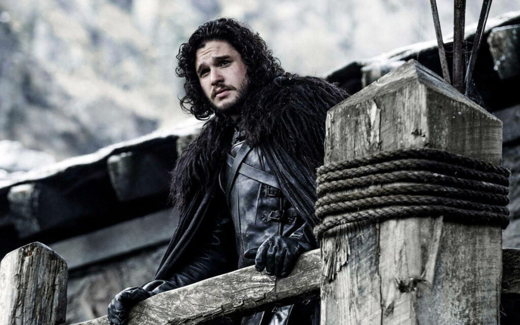 Jon Snow: Iconic Black Attire on Wooden Porch - Game of Thrones Wallpaper