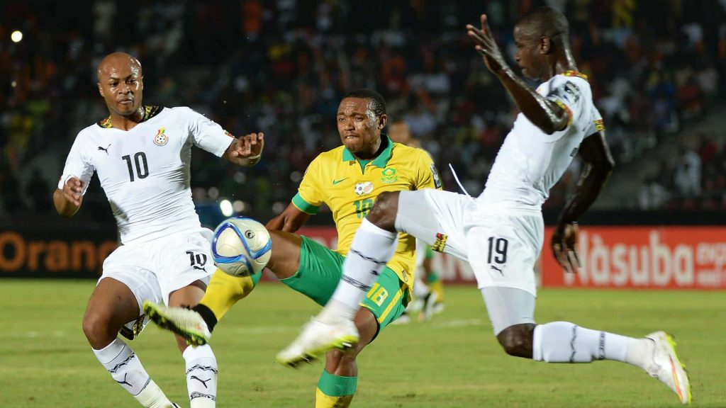 Ghana footballer Jonathan Mensah number 19 challenges for ball in intense African match action Wallpaper