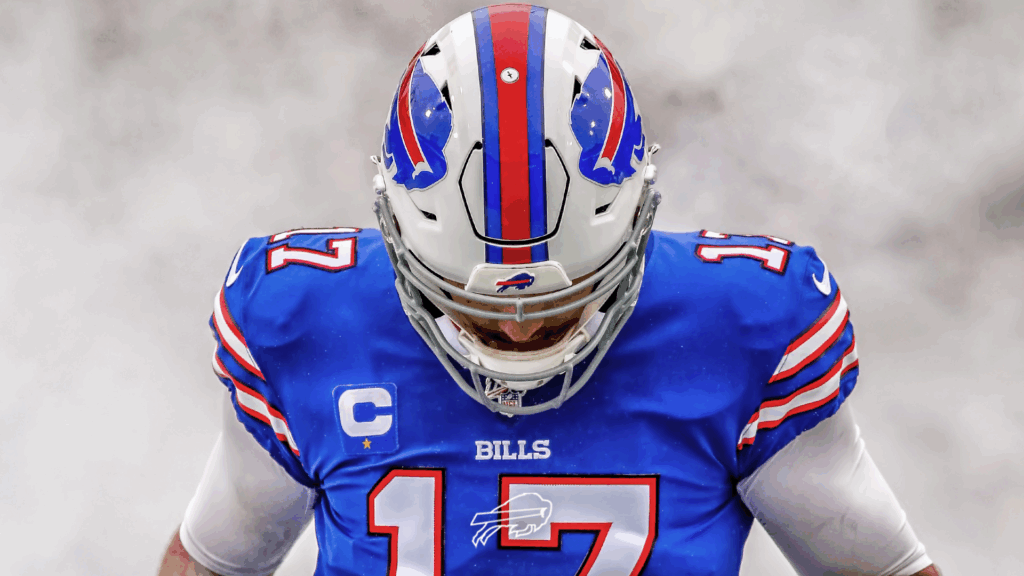 Josh Allen in blue Buffalo Bills uniform and helmet with intense focused stance in misty background Wallpaper