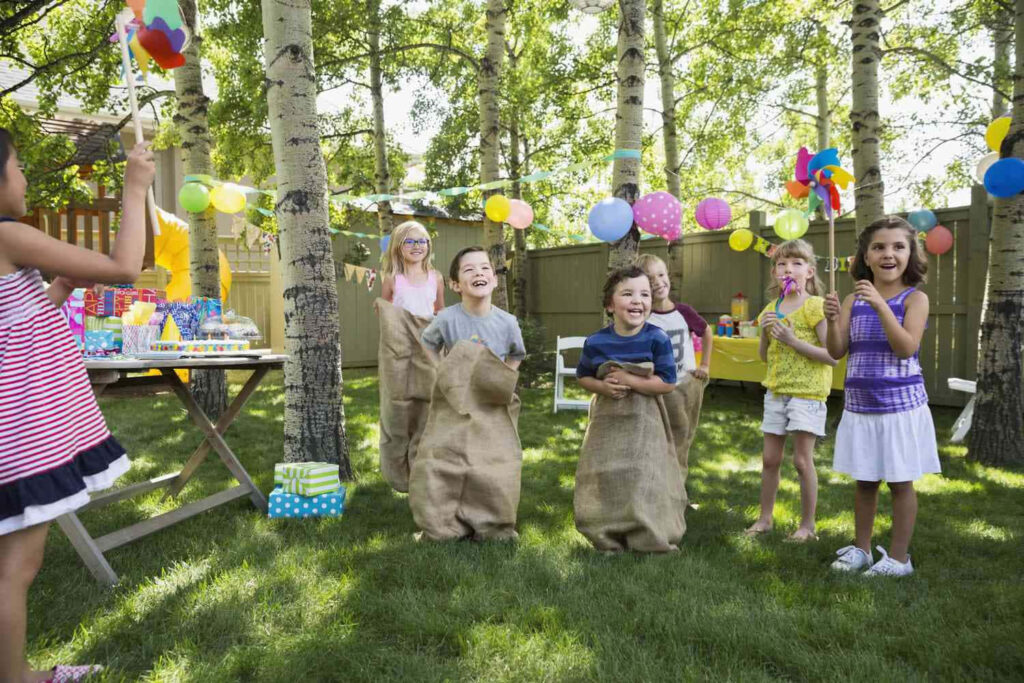 Kids Enjoy Sack Race at Colorful Backyard Birthday Party Wallpaper
