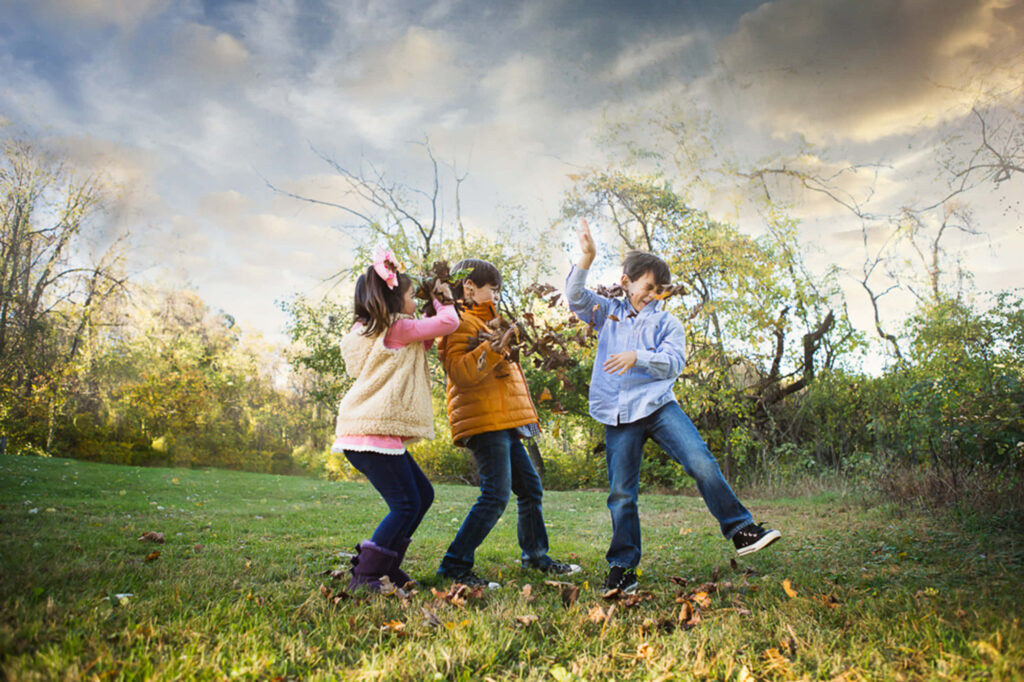 Children playing outdoors under autumn leaves vibrant wallpaper capturing friendship and adventure