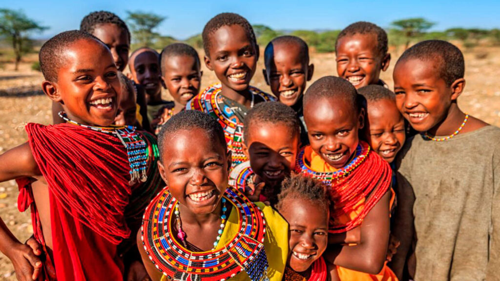Joyful children in vibrant traditional clothing and beaded necklaces smiling outdoors in sunlight Wallpaper