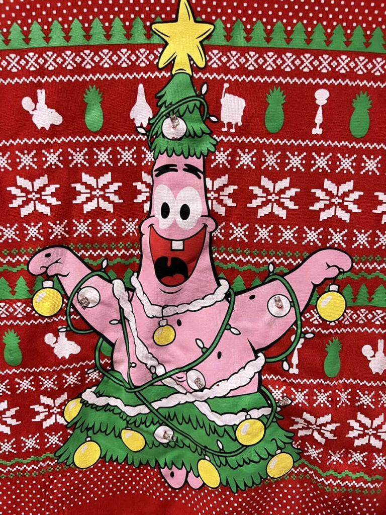 Joyful Christmas Tree Character on Festive Knitted Wallpaper