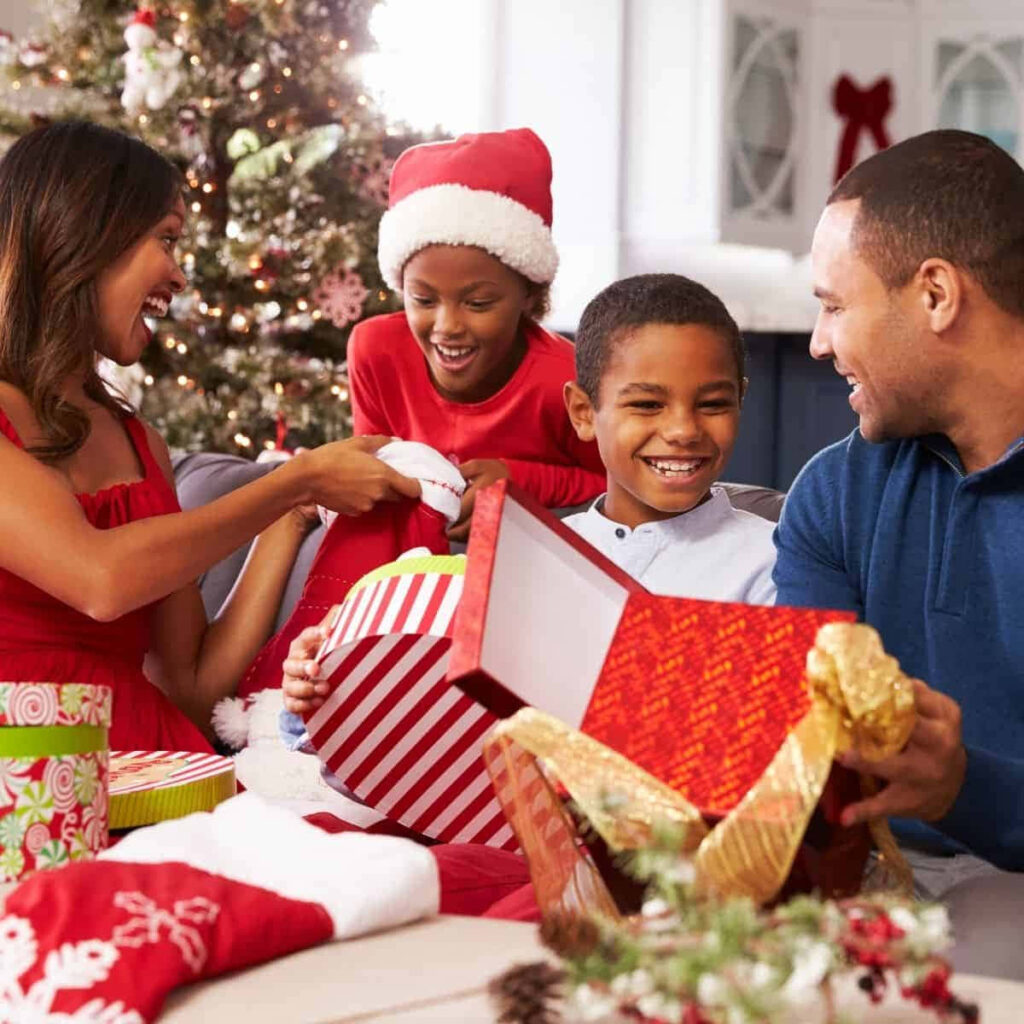 Joyful Family Celebrates Around a Festively Decorated Christmas Tree Wallpaper