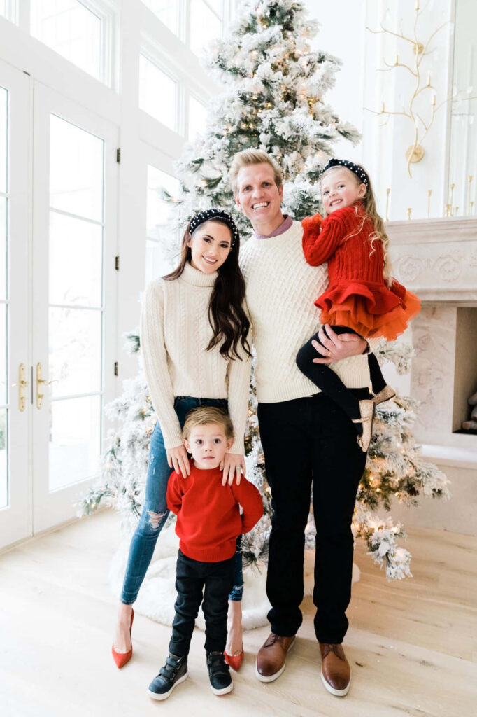Joyful Family Holiday Photo by a Festively Decorated Christmas Tree Wallpaper