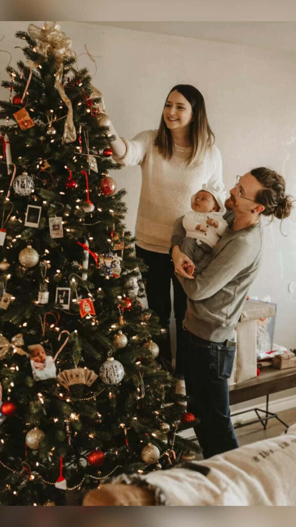 Joyful Family Decorating Christmas Tree with Newborn Baby Wallpaper