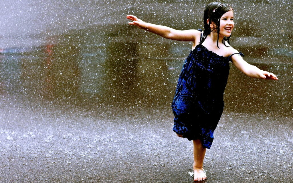 Blissful Moments: The Rainy Dance of a Joyous Kid in HD Wallpaper