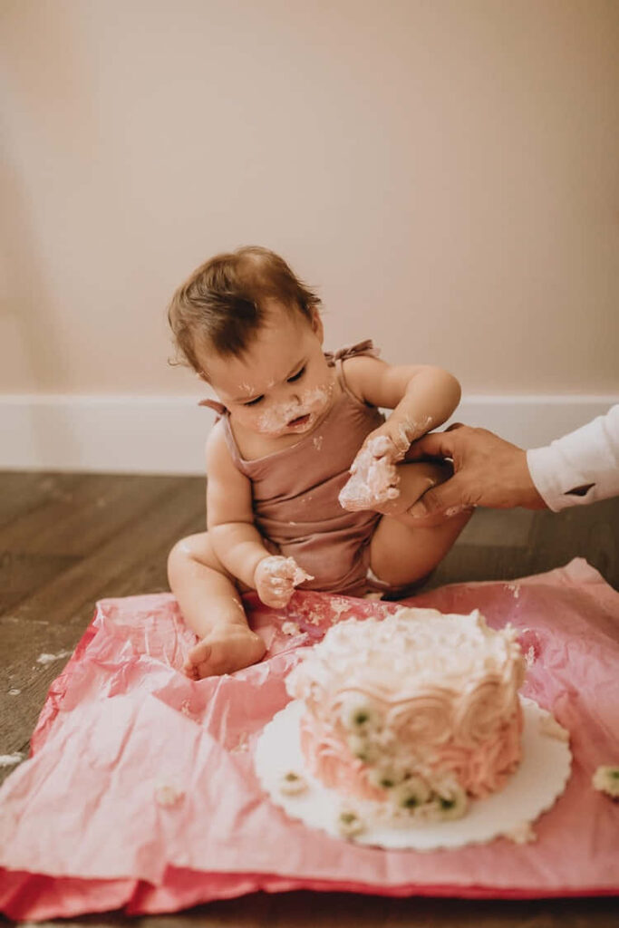 Joyful Toddler Cake Smash: Whimsical Moments in Pink and Cream Wallpaper