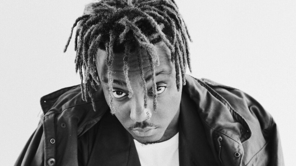 High-contrast grayscale Juice Wrld portrait with dreadlocks nose ring dark jacket wallpaper background