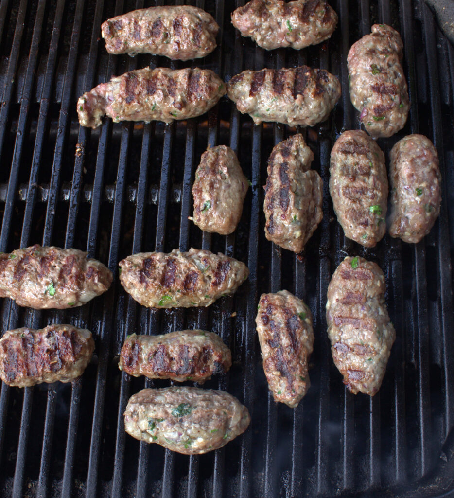 Juicy ćevapi sausages grilling with rich textures and savory grill marks on rustic grate Wallpaper