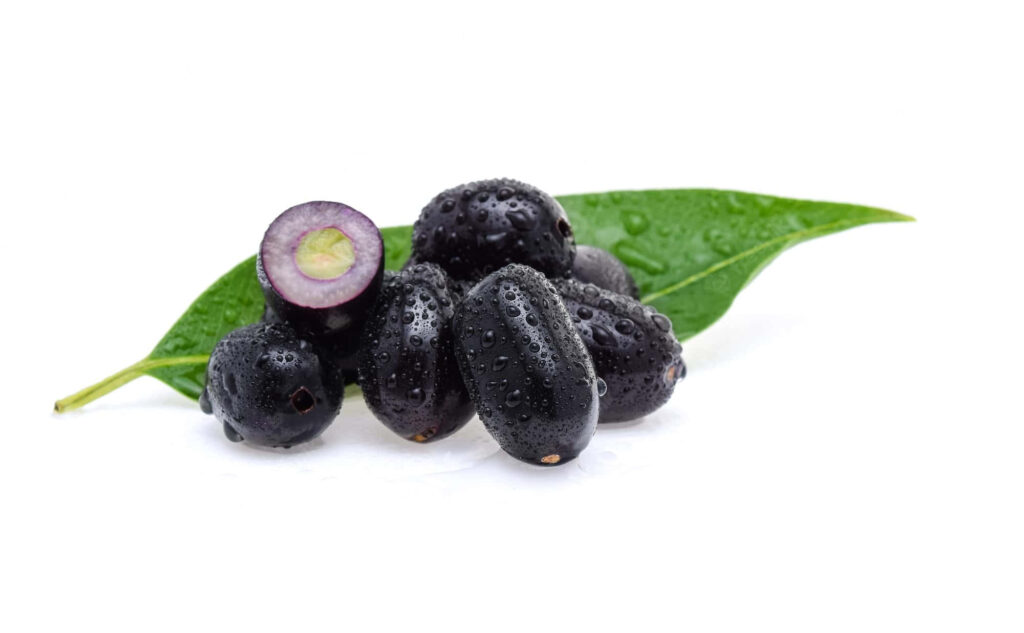 Fresh juicy Java plums with water droplets on green leaf showcasing rich purple color on white background Wallpaper