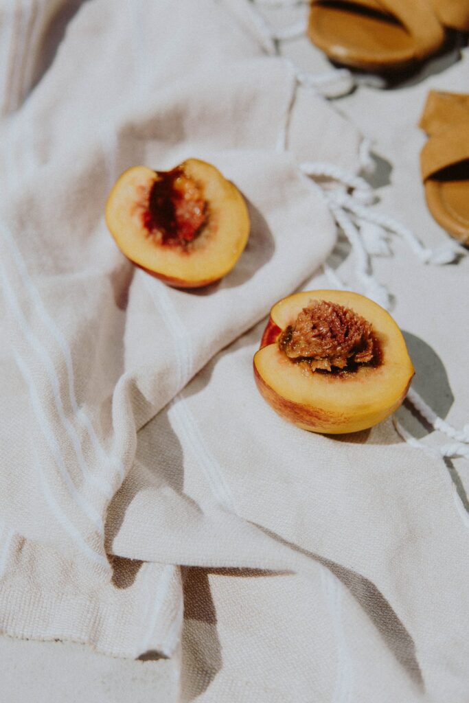 Vibrant Peach Halves on Cloth - Fresh Fruit Wallpaper Background