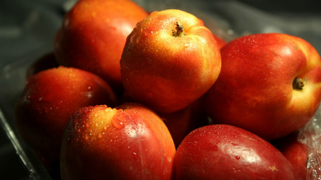 Juicy Delight: HD Wallpaper of Freshly-Picked Ripe Nectarine with High Definition Clarity as the Background