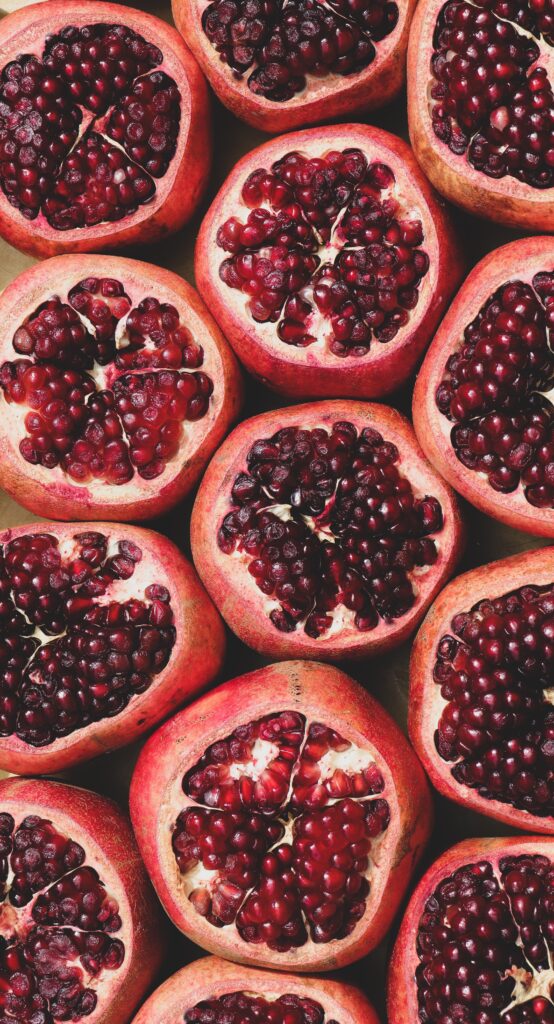 Vibrant Pomegranate Halves Wallpaper: Fresh & Abundant Background