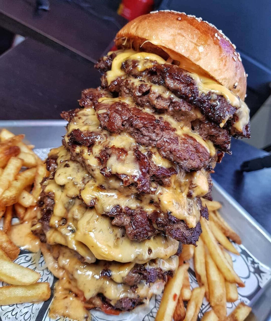 Juicy Burger Stack with Fries - Delicious Wallpaper Background