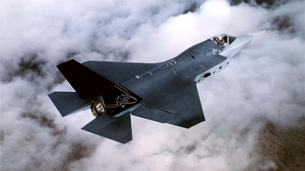Alone in the Sky: Lockheed Martin X-35 Soars Above Jumbo Jet Backdrop Wallpaper