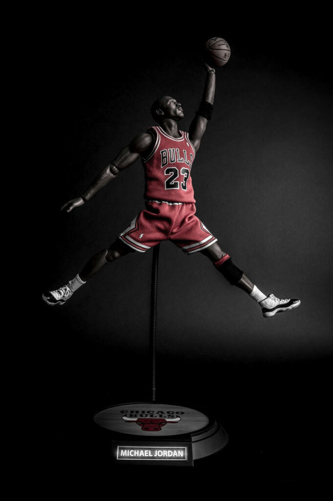 The Airborne Legend: Michael Jordan's Spectacular Leap on Bulls Display Stand Wallpaper