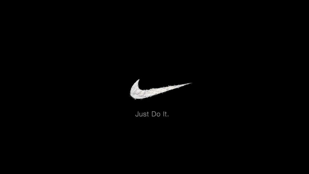 Empowering Nike's Iconic Just Do It! Logo Shines on a Majestic All-Encompassing Dark Canvas Wallpaper