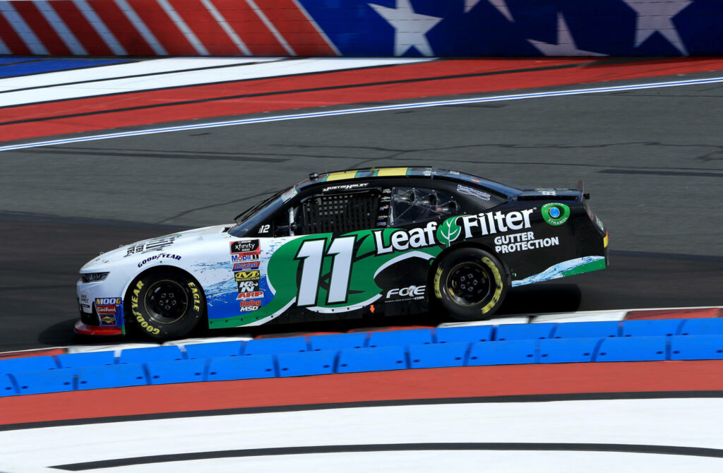 Justin Haley racing No 11 LeafFilter car at high speed on NASCAR track with dynamic motion Wallpaper