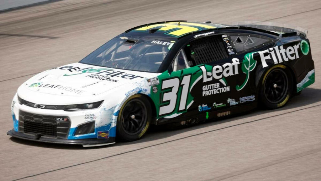 Justin Haley race car with Leaf Filter branding speeds on track dynamic racing sponsor decals Wallpaper
