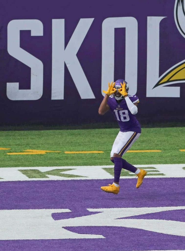 Justin Jefferson performing Griddy touchdown celebration in purple Vikings uniform stadium backdrop Wallpaper