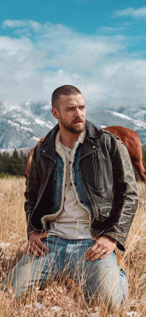 Justin Timberlake Kneeling in Rustic Outdoor Setting - Wallpaper