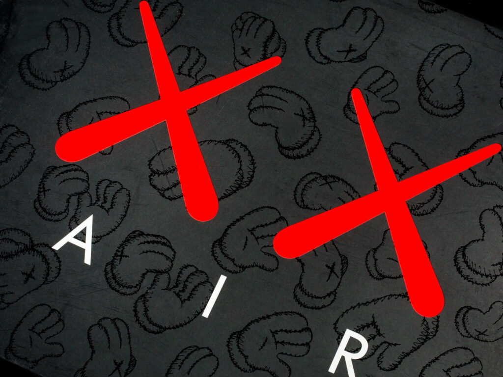 Dark wallpaper with KAWS gloved hands pattern red X marks and white AIR text background design