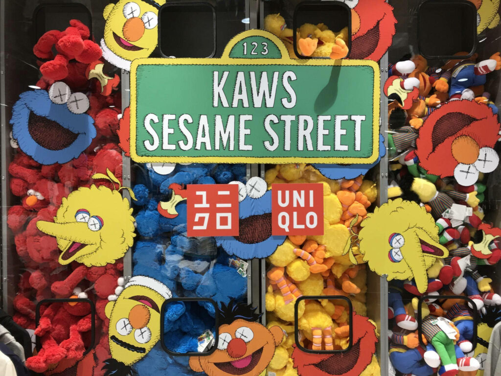 Playful KAWS Sesame Street colorful cartoon characters wallpaper for UNIQLO collaboration background