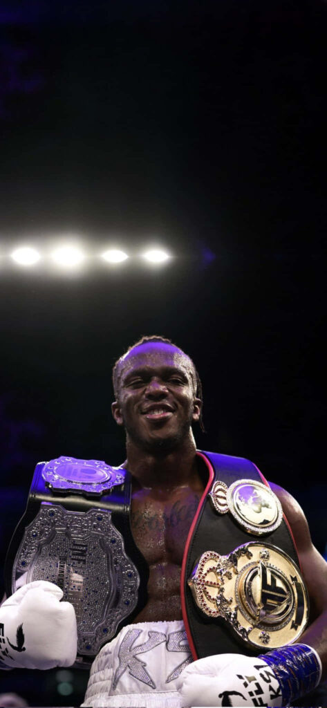 KSI British rapper influencer boxer on stage with championship belts and boxing gloves celebrating Wallpaper