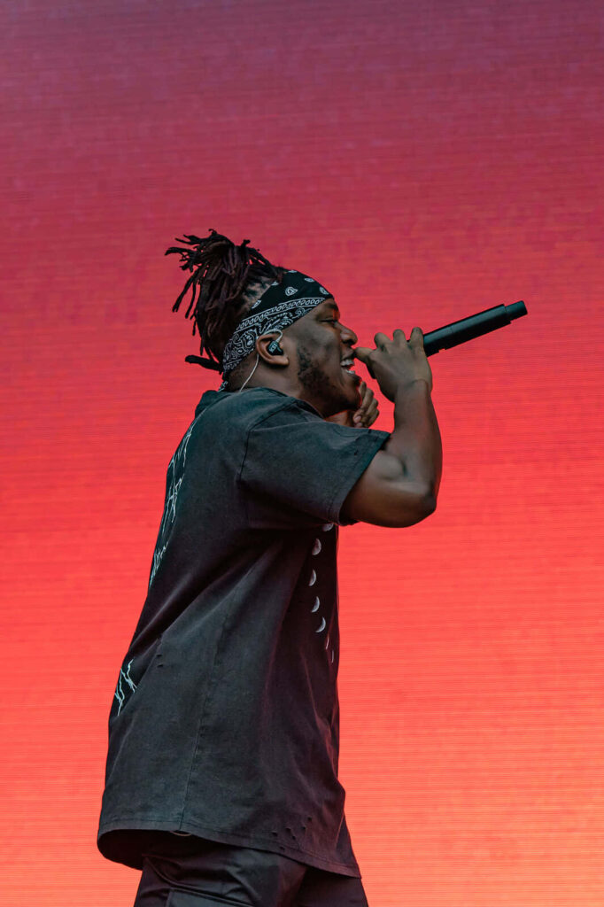 KSI passionately singing on stage with vibrant red background British influencer musician boxer Wallpaper