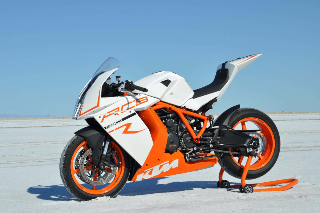 Vibrant KTM RC 8R Motorcycle Wallpaper in Snowy Landscape Background