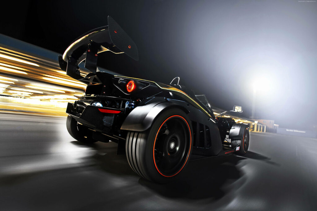 Sleek black KTM X-Bow sports car racing at night with red accents and dramatic lighting wallpaper