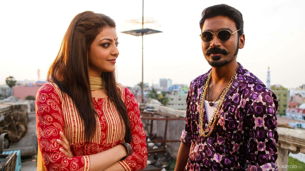 Kajal Aggarwal and Dhanush on sunlit rooftop in vibrant traditional and modern outfits urban skyline Wallpaper